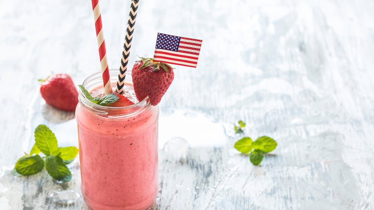 Bright pink milkshake with strawberries and U.S. flag