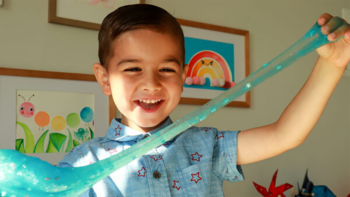 A young boy playing with blue slime