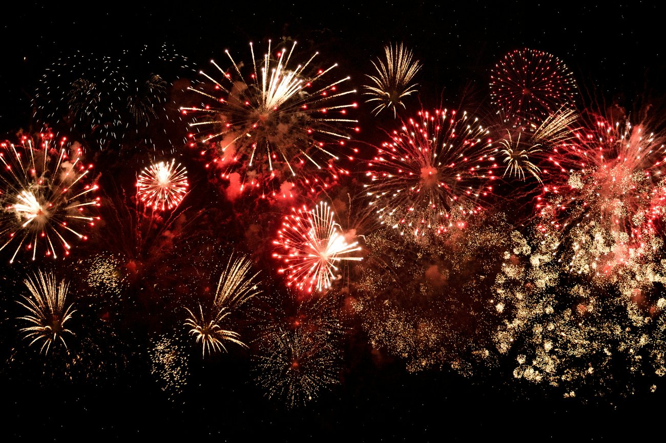 Brilliant display of red and white fireworks in the dark night sky