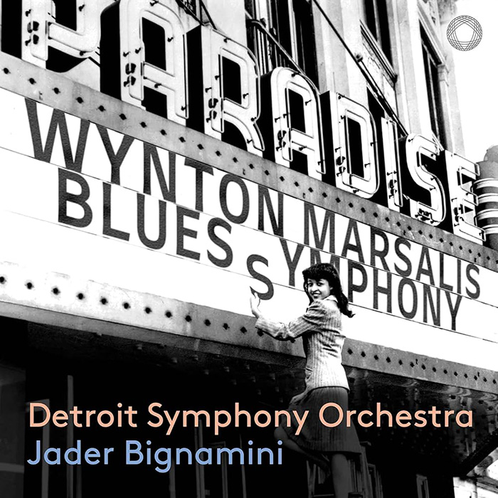 Woman puts up words "Wynton Marsalis Blues Symphony" on an old-fashioned marquee