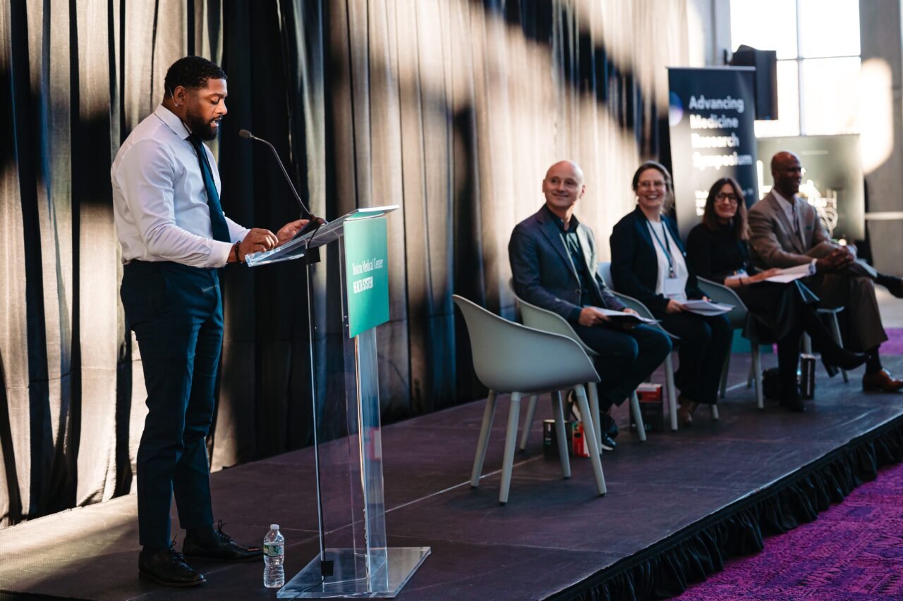 Moderator Clifford Harrison, CEO of BlueBridge, opens the first panel session at the Advancing Medicine Research Symposium.