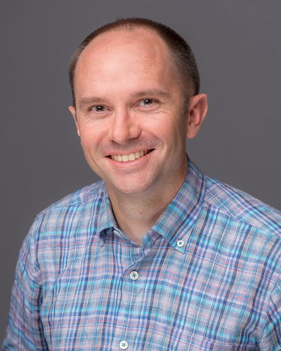 Matt Jones Extension Agent, Agriculture - Commercial Ornamental & Consumer Horticulture wearing a blue plaid shirt, thinning brown hair and smiling with a neutral background.