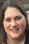 Brandi King County Extension Administrative Assistant smiling with long dark hair.