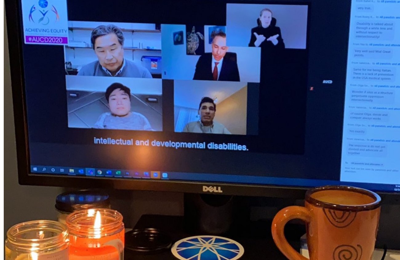 This image shows a computer screen displaying a virtual meeting with five participants in a video call. There is a sign language interpreter in the top right corner, and subtitles at the bottom of the screen read "intellectual and developmental disabilities." The top left corner has a logo with the text "ACHIEVING EQUITY #AUCD2020."