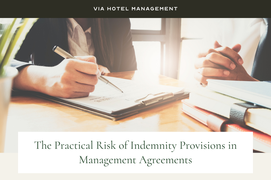 Via Hotel Management mage: person writing on clipboard at desk. Another person has their hands clasped waiting next to them. 