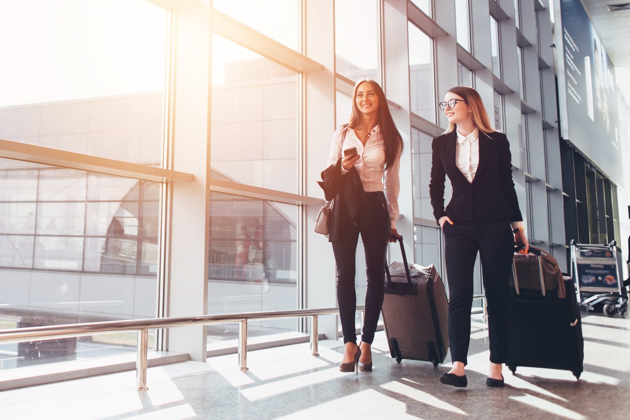 Two business women walk through the airport.