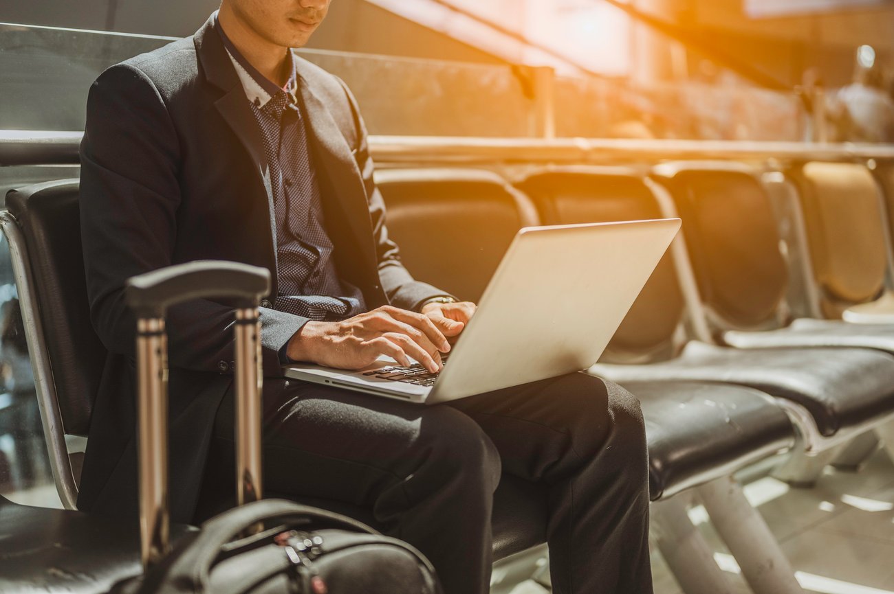 Man Using Laptop While Sitting At Airport 