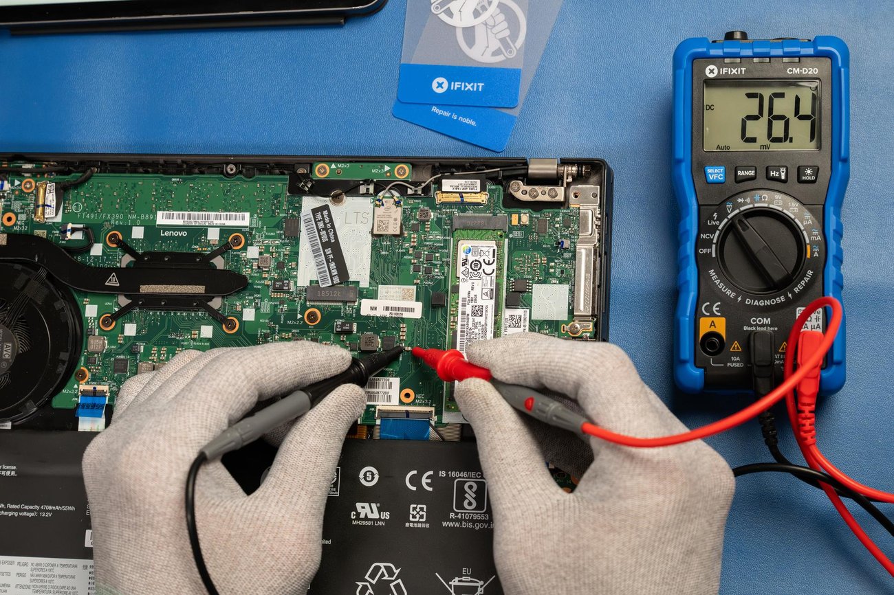A repair tech uses the iFixit Digital Multimeter to read a laptop's board voltage. A repair tech uses the iFixit Digital Multimeter to read a laptop's board voltage.