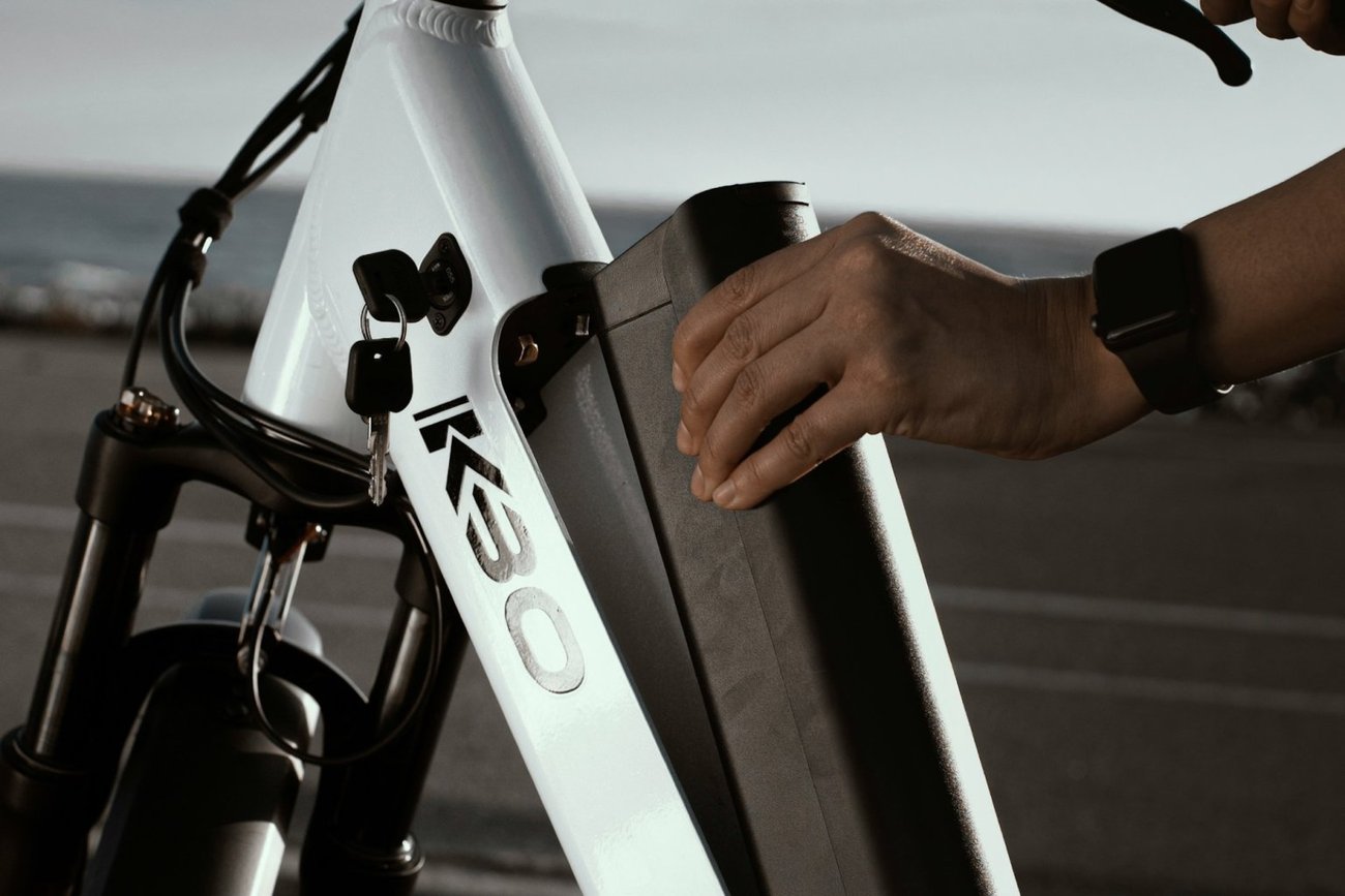 Hands removes the battery from a KBO e-bike.