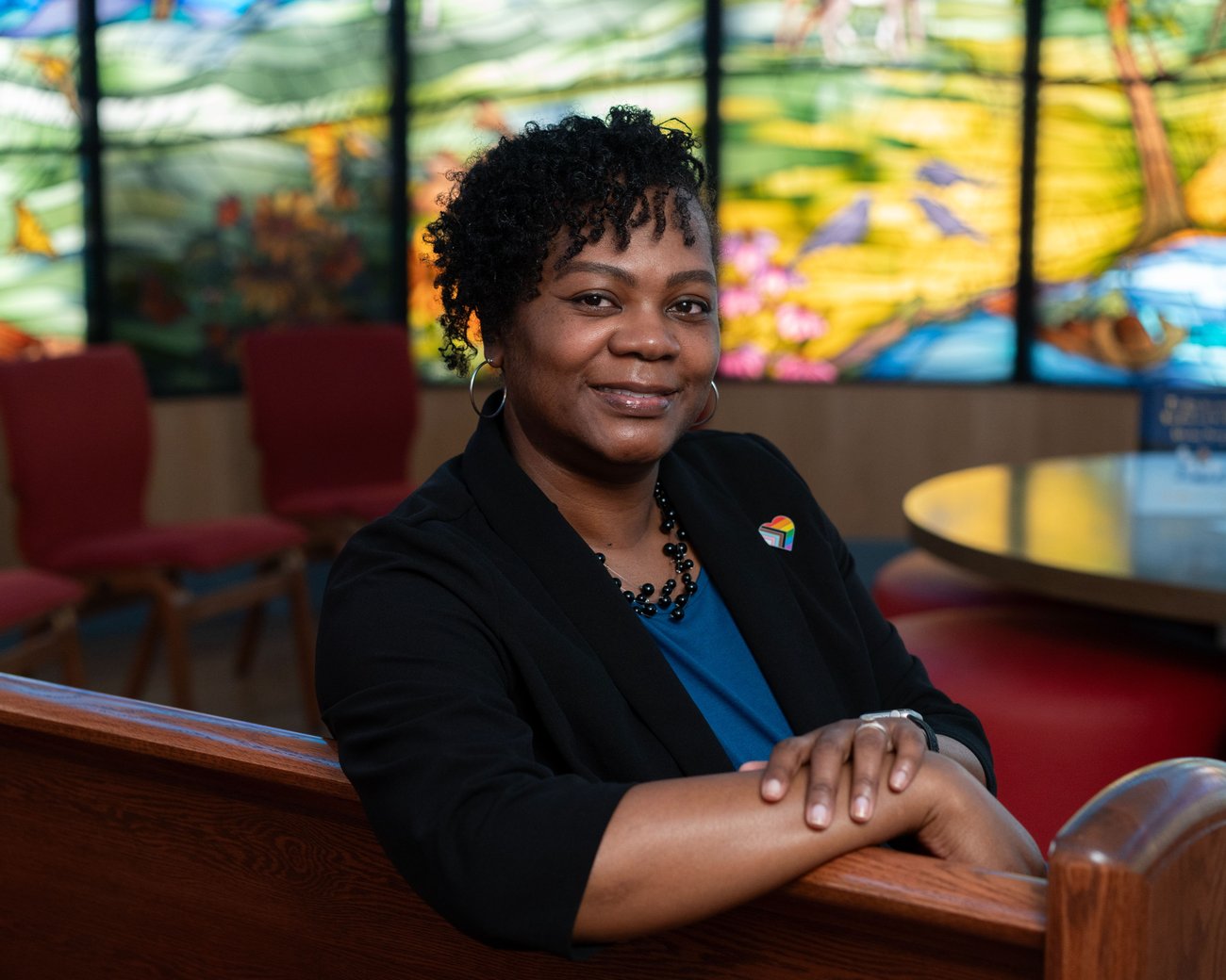 lady smiling, wearing a black blazer and blue shirt
