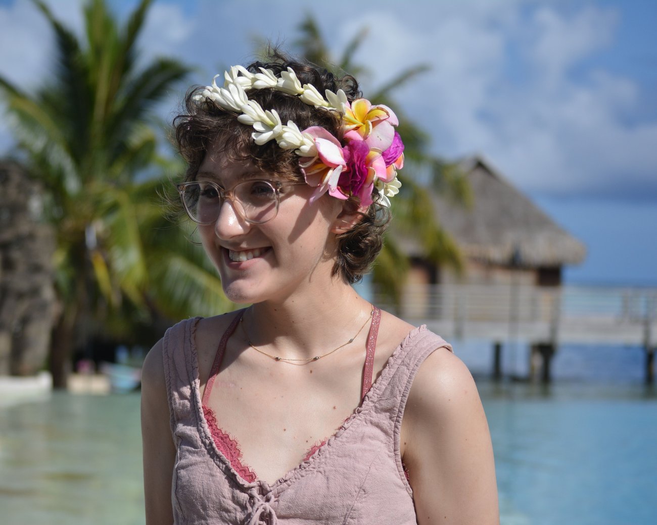 young lady with flowers in her hair with water in the background