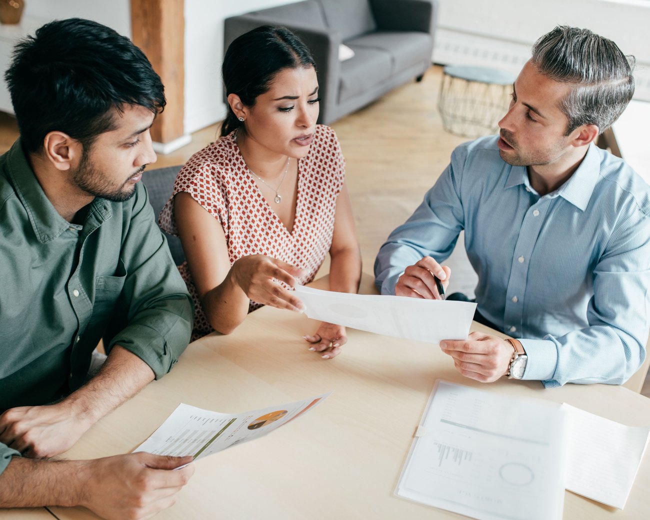 A man holding a paper and showing it to man and women