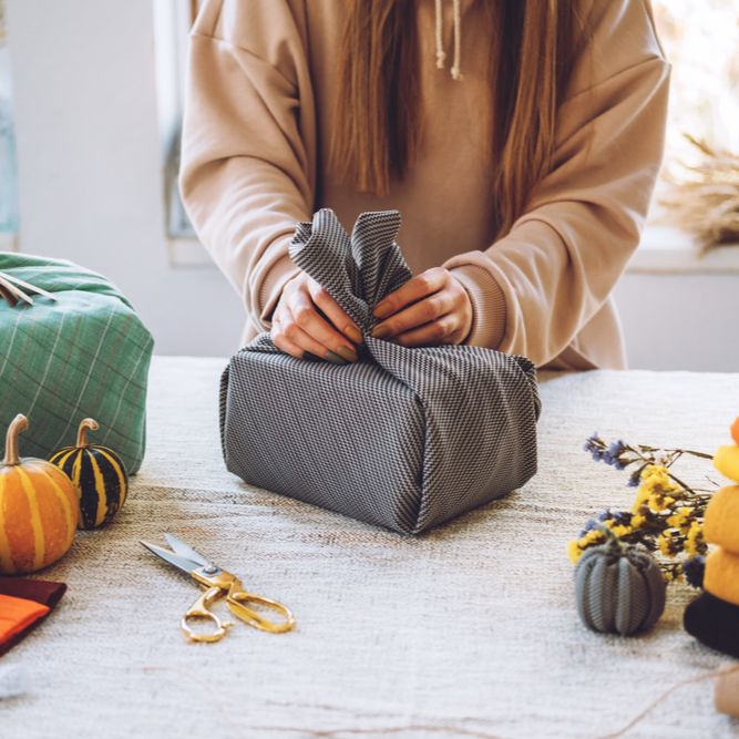 Female in a brown shirt, wrapping presents 
