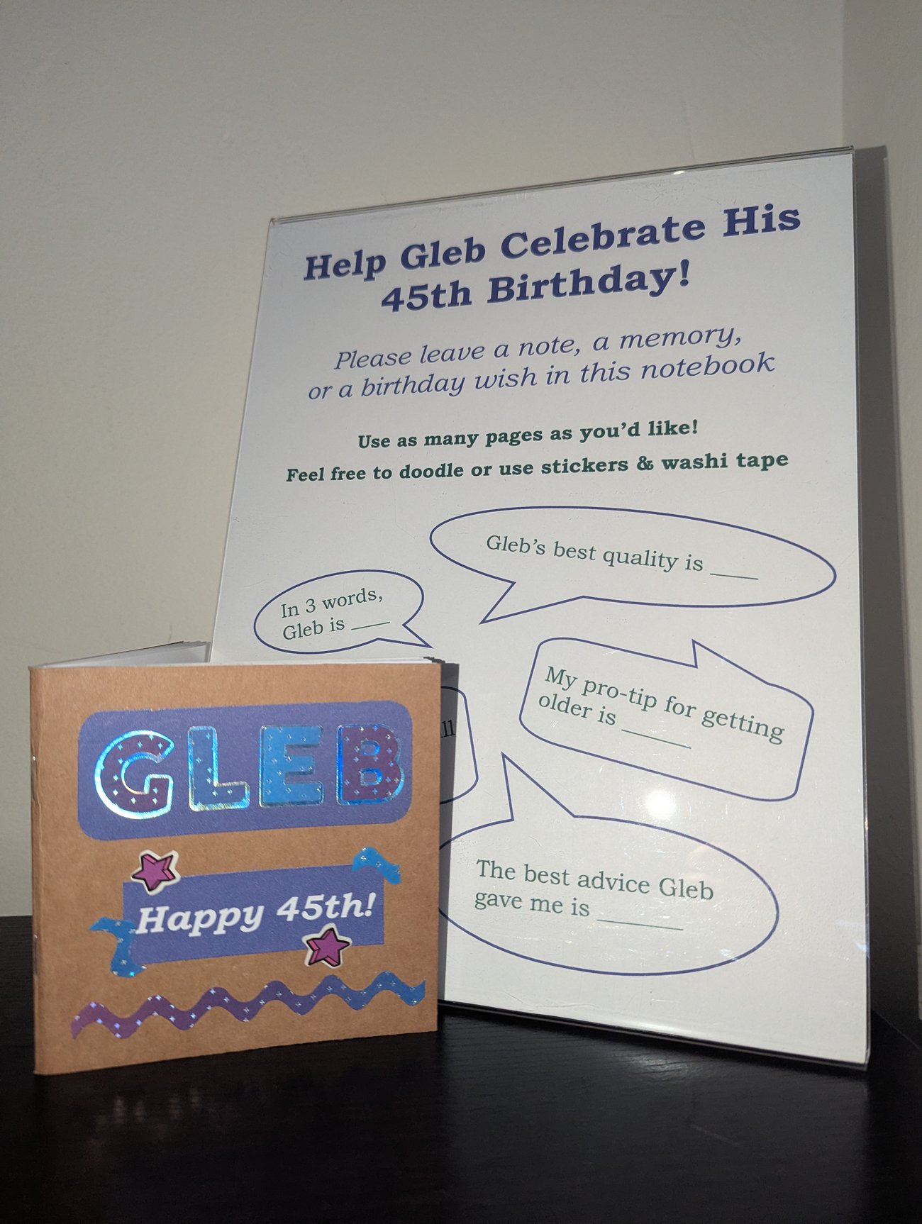 photo of small notebook with a sign encouraging guests to write a birthday greeting for Gleb