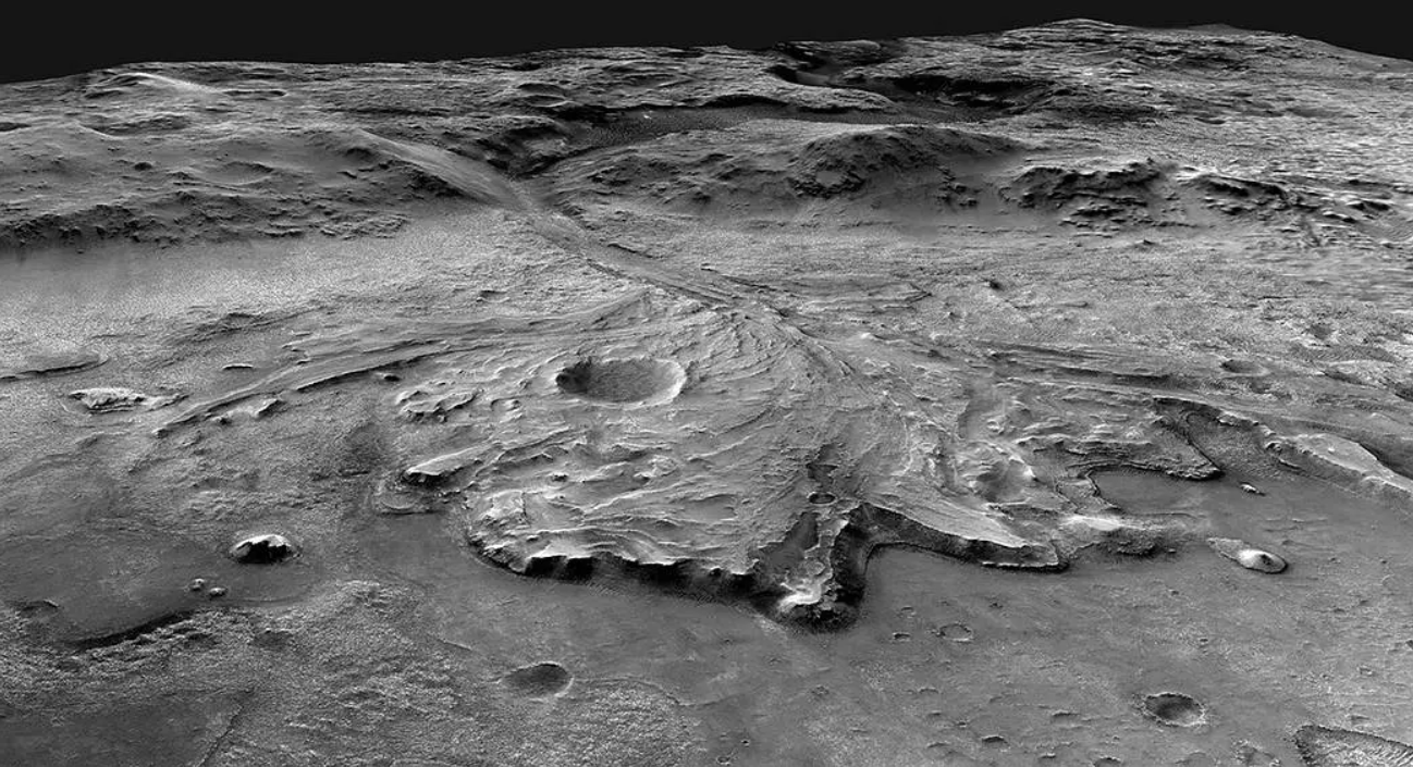 A large grey rocky landscape on Mars A higher elevation area in the background includes the old marks of a riverbed which move towards the forefront of the image