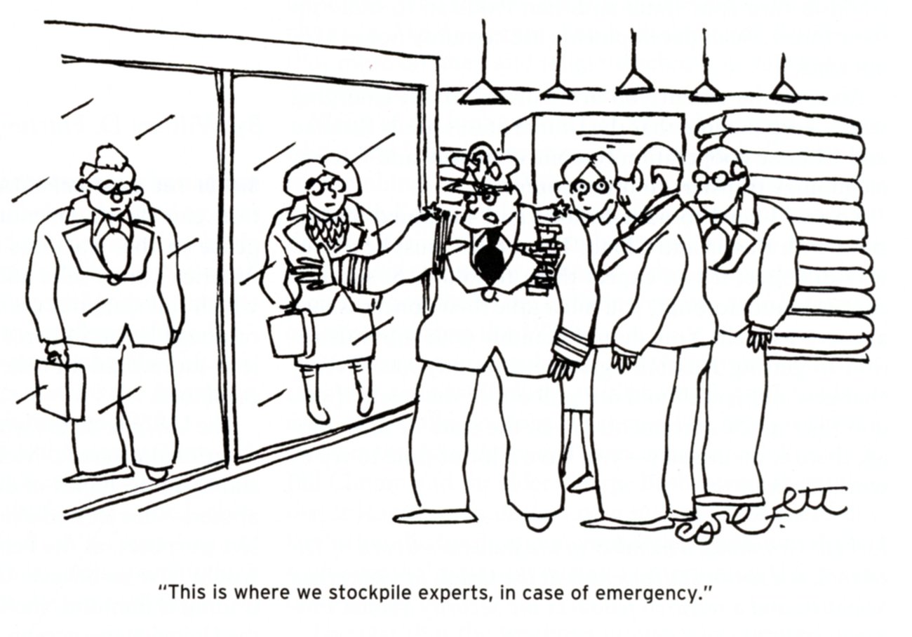 A military officer motions to two experts standing behind glass walls and says to a group of officials This is where we stockpile experts in case of emergency