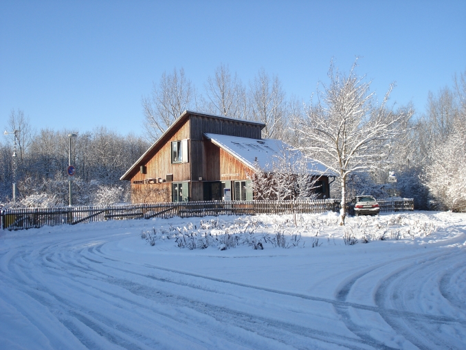 Blick auf das winterlich verschneite Naturschutzzentrum Schleipfuhl.