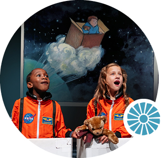 Two children in orange astronaut suits look up with amazement. Behind them, a screen shows an illustration of a child blasting off to Space inside a cardboard box.