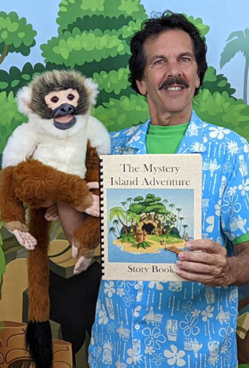 Marco and his monkey puppet holding the book