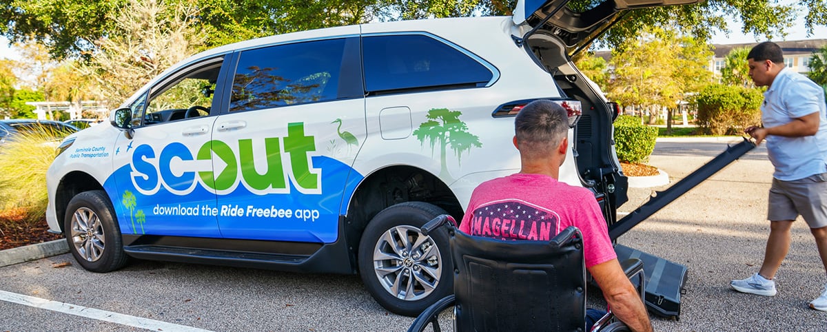 person in wheelchair getting assistance loading into SCOUT van