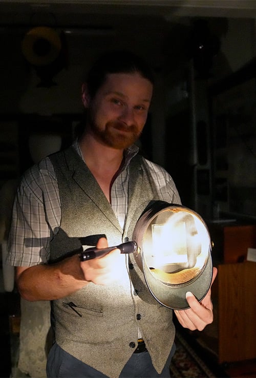 Tour guide holding flashlight to hat