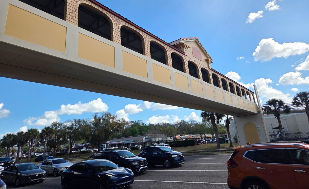 bridge over roadway traffic with blue sky and clouds overhead bridge over roadway traffic with blue sky and clouds overhead