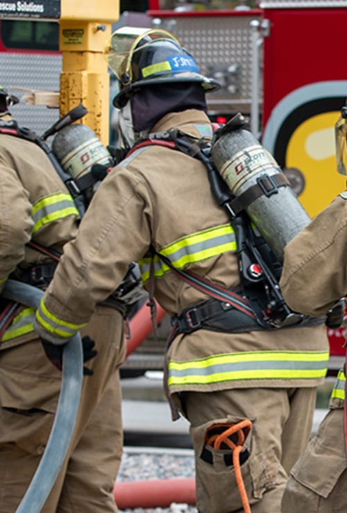 firefighter in gear pulling hose