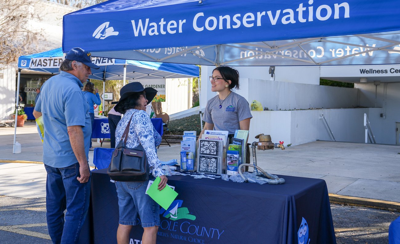 girl at water conservation tent talking to couple girl at water conservation tent talking to couple