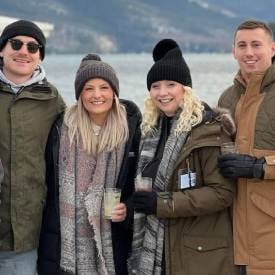people with drinks in winter in lake george