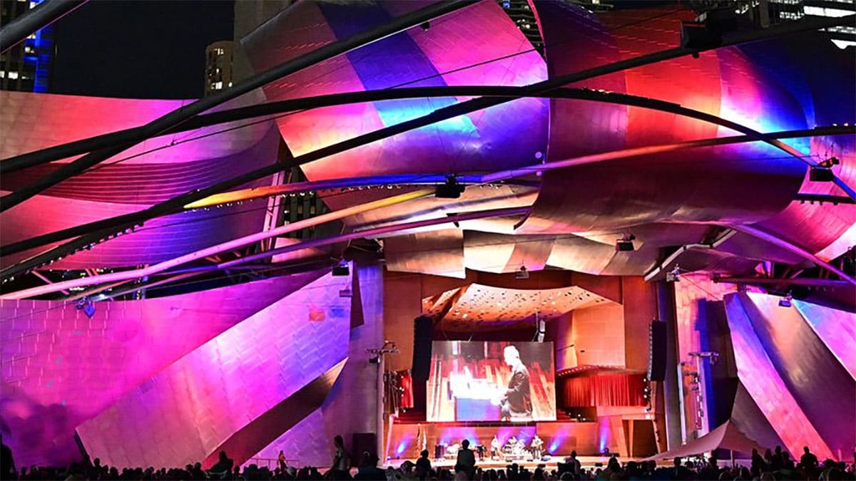 Millennium Park Pritzker Pavilion illuminated by vibrant purple and pink lights Millennium Park Pritzker Pavilion illuminated by vibrant purple and pink lights