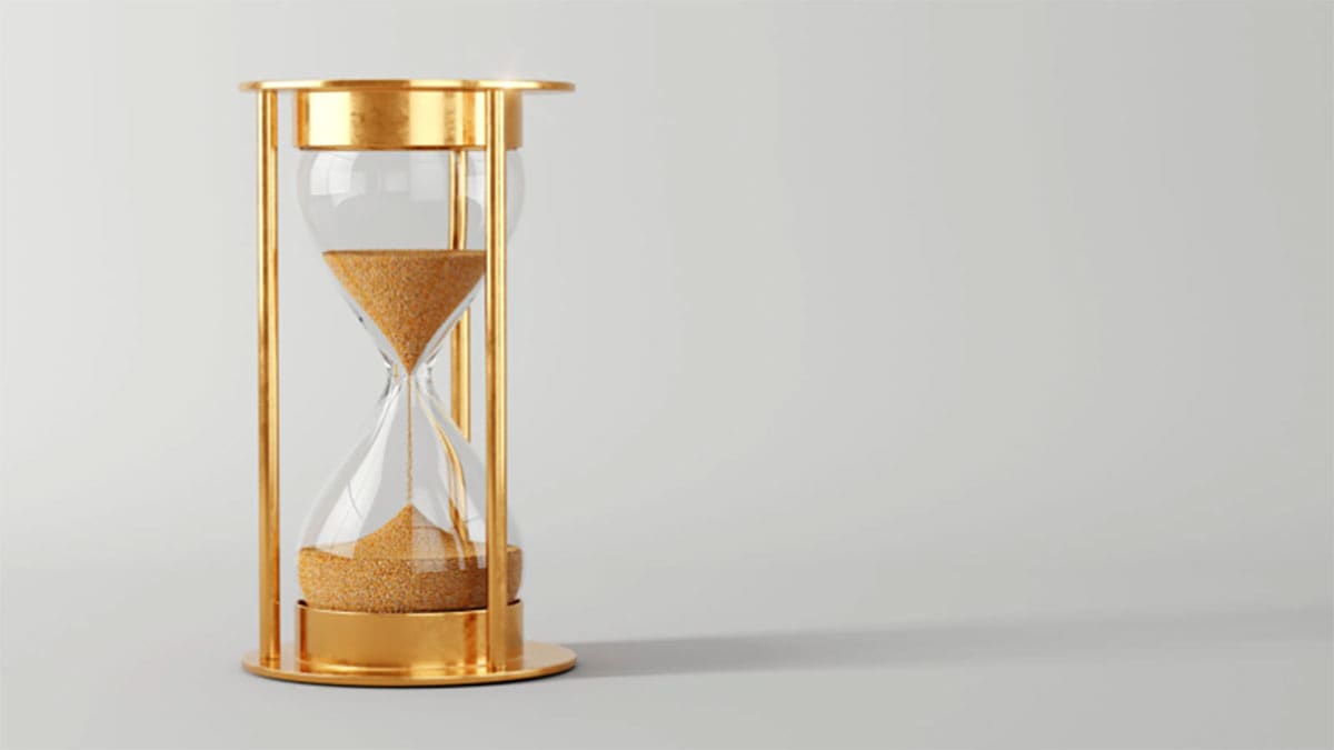 A brass hourglass with half of the sand left to fall A brass hourglass with half of the sand left to fall
