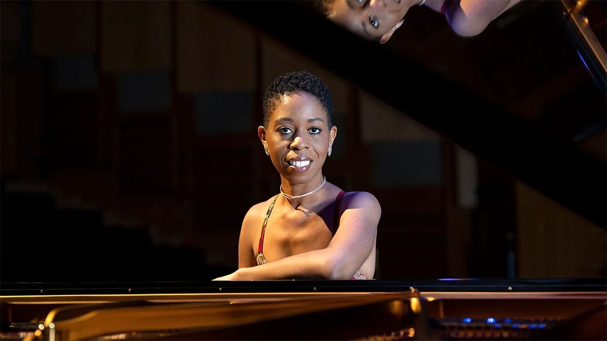 Pianist Dr. Samantha Ege sits at a grand piano Pianist Dr. Samantha Ege sits at a grand piano