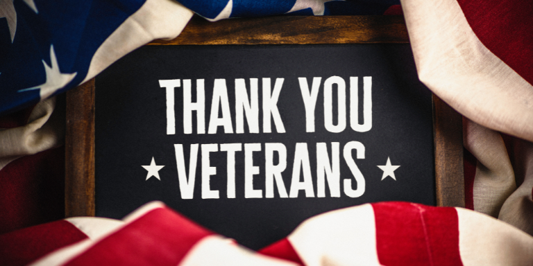 Photo of a sign that reads 'Thank You Veterans' surrounded by the American flag. Photo of a sign that reads 'Thank You Veterans' surrounded by the American flag.