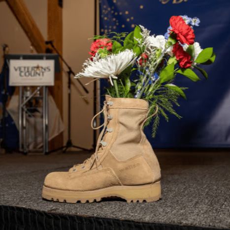 Two men cooking over a grill outside.