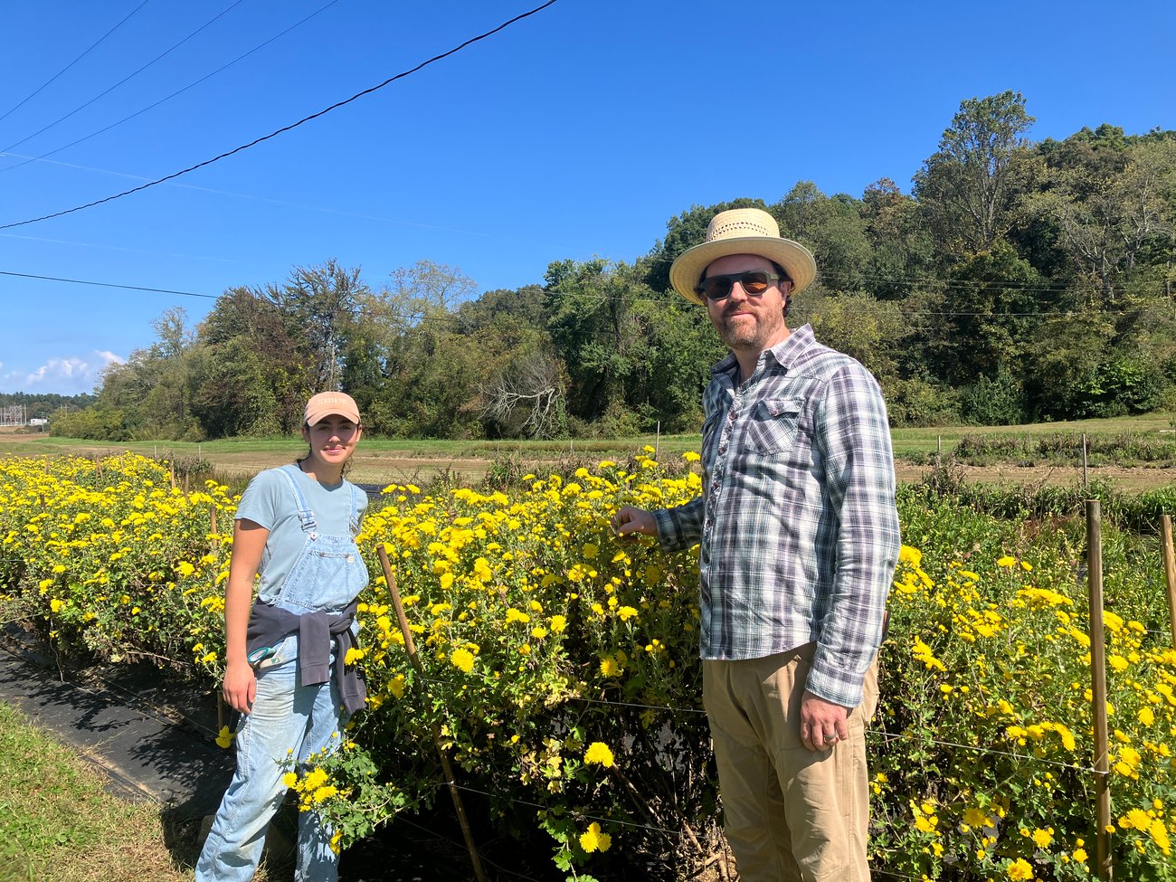 Harley and Adam standing in front of a row of juhua.