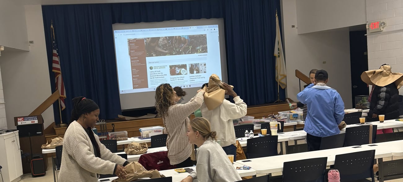 Photo from NC Cooperative Extension Guilford County Center Open House. People conversing and visiting information tables in the lobby. 