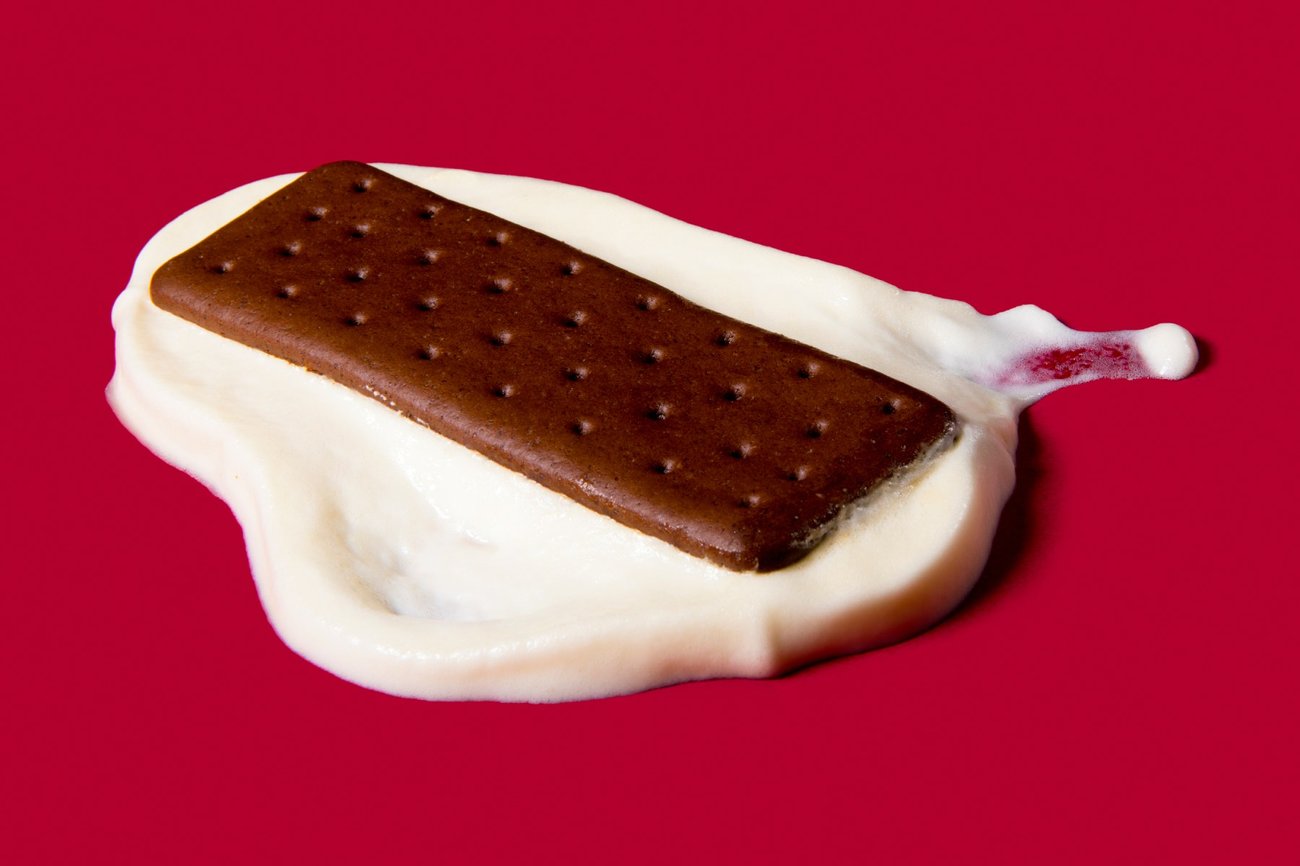 A photo of a melted ice cream sandwich on a red background. A photo of a melted ice cream sandwich on a red background.