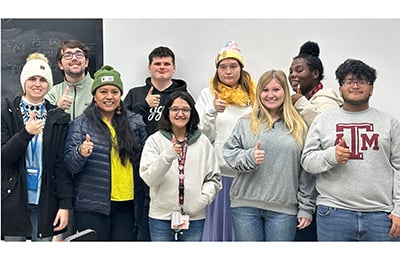 A group of PATHS studens standing together with thier thumbs up. 