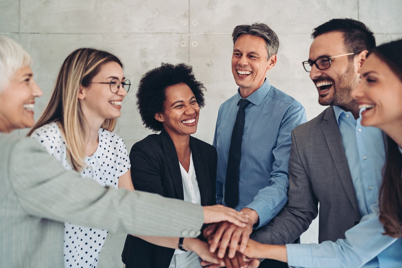 group of business people standing in a circle with stacked hands