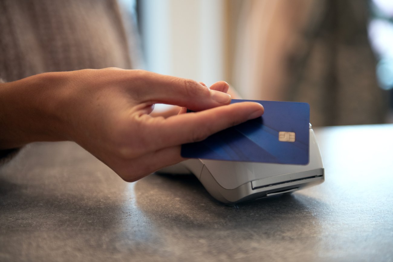 Woman holding out credit card to pay.