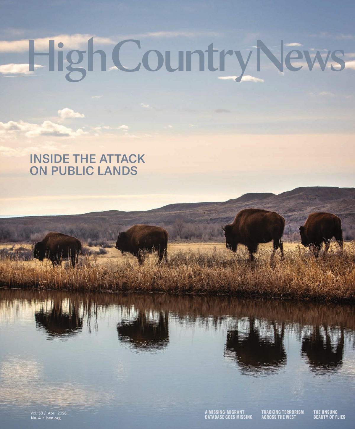 The cover of the April 2026 issue shows 4 bison walking through reeds along a river in Yellowstone National Park, with their reflections visible in the gently rippling surface of the river.