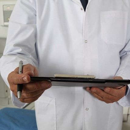 Doctor holding a clipboard and a pen