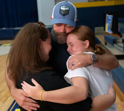 Photo of a young lady in a pink coat outside. 