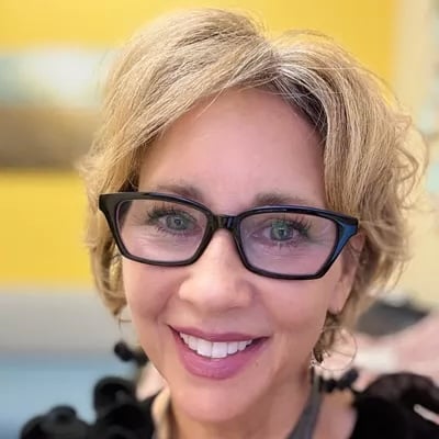 image of a women wearing black glasses and smiling