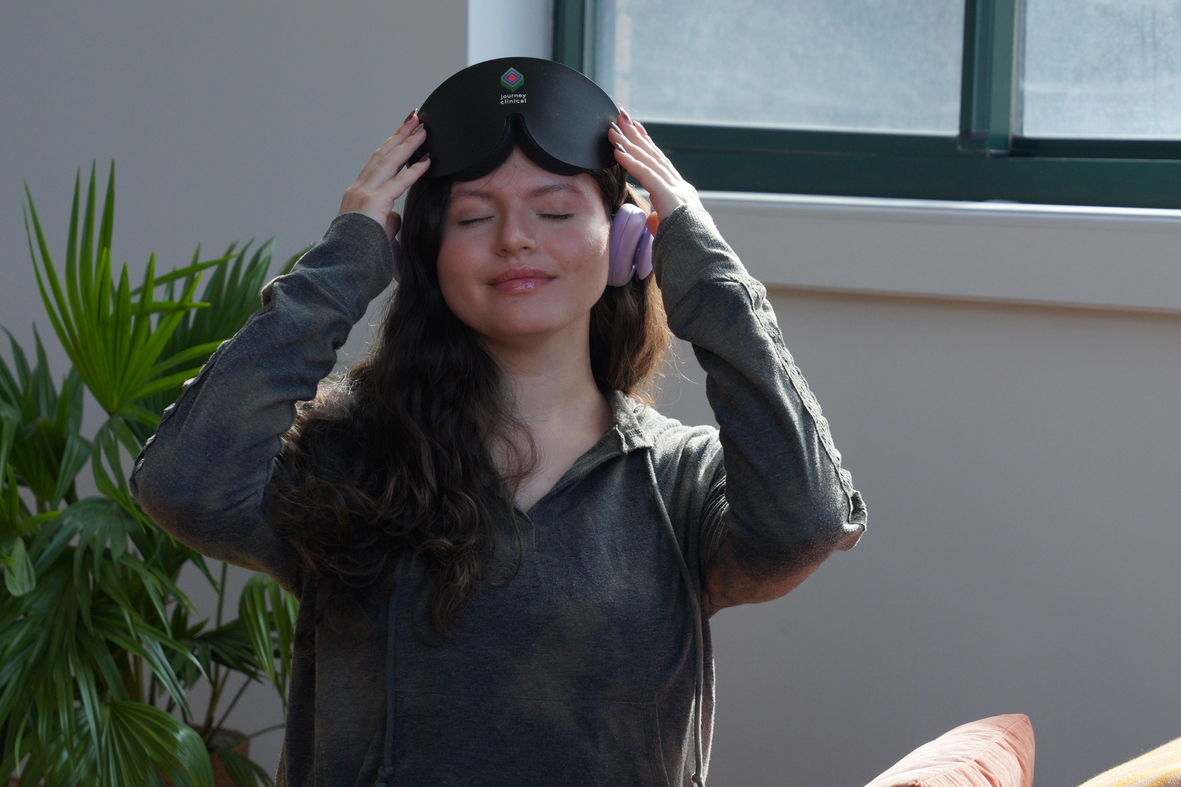 smiling patient adjusting eye mask and headphones