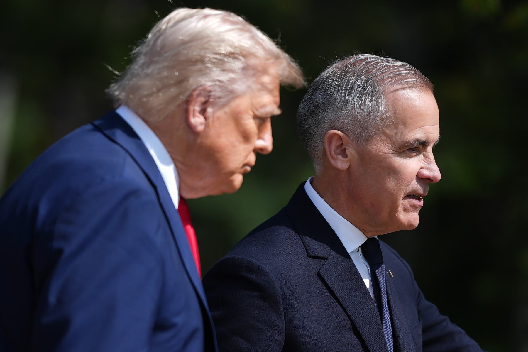 A photo of Donald Trump and Mark Carney, taken from the side with Trump glowering.