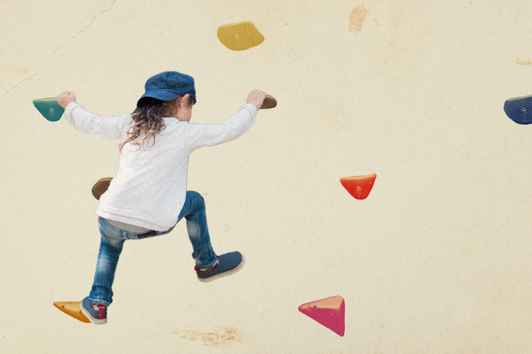 A child tries to climb a rock climbing wall.