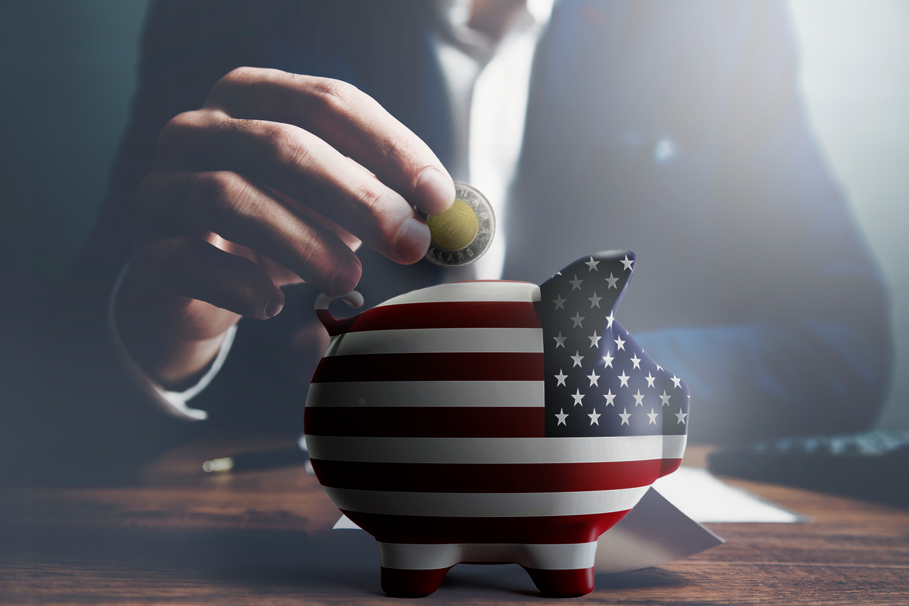 A photo illustration of a man in a suit putting a toonie into a piggy bank covered in the American flag.