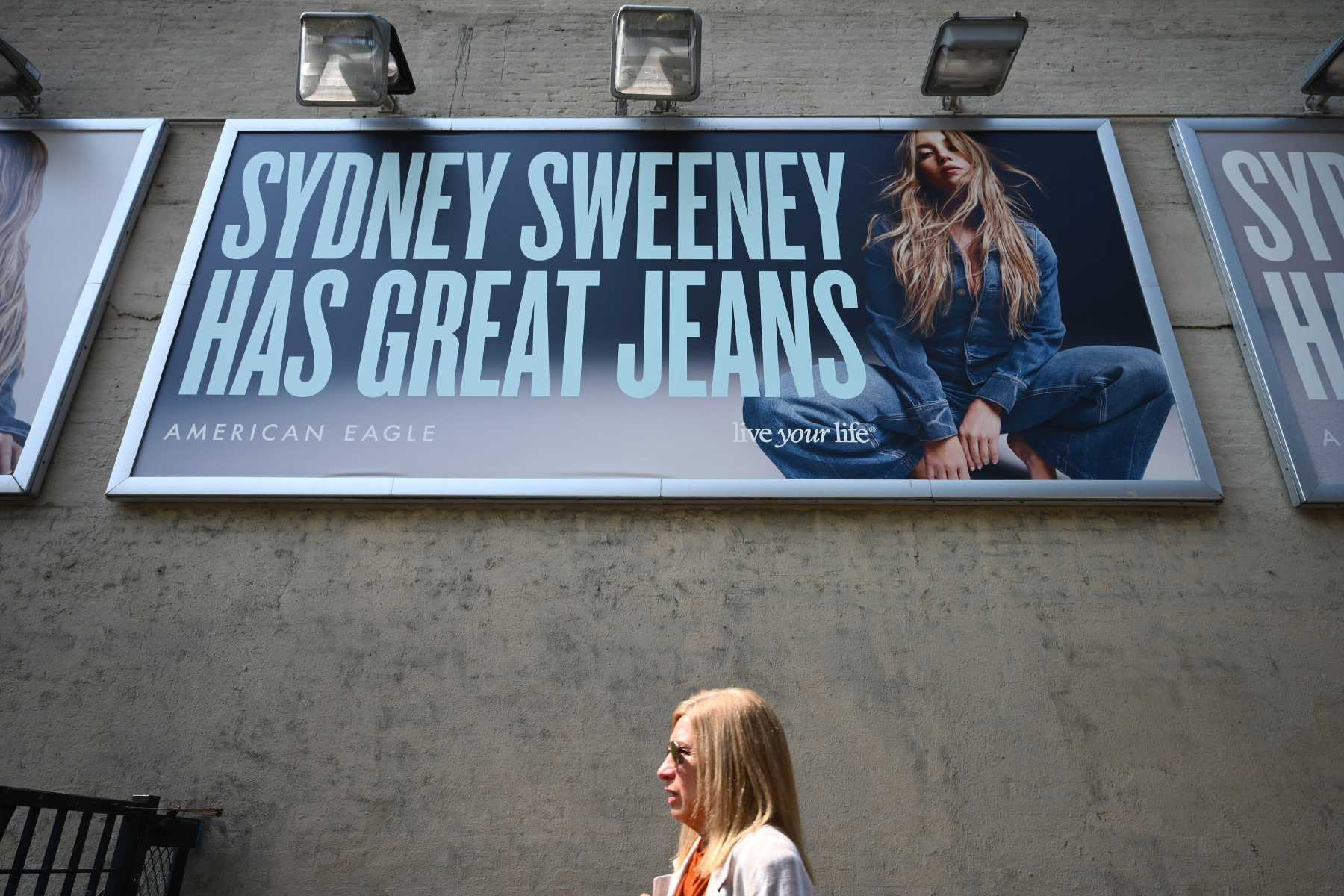 A photo of a woman walking below an ad for American Eagle with a blonde woman that reads 'Sydney Sweeney has great jeans.'