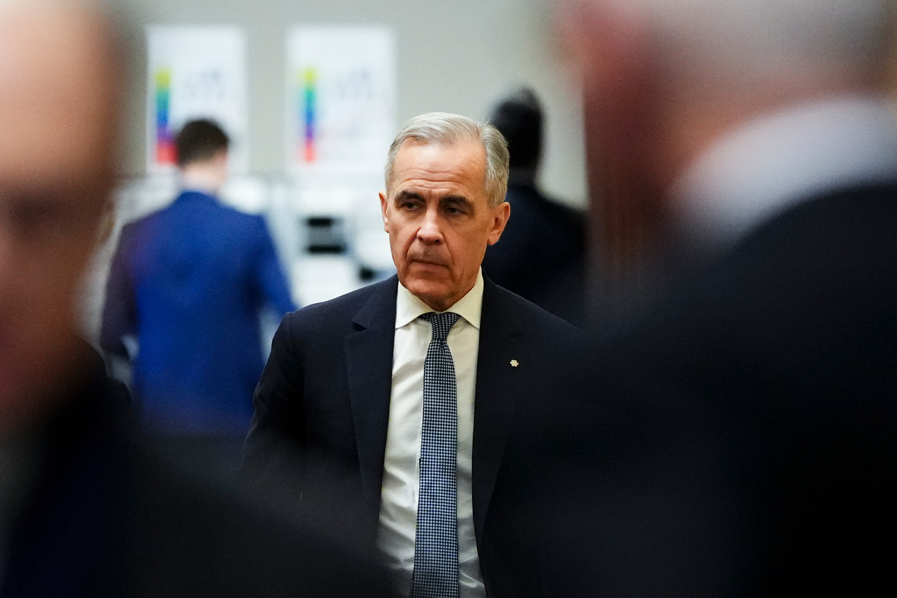 Mark Carney walks in a hallway looking concerned.